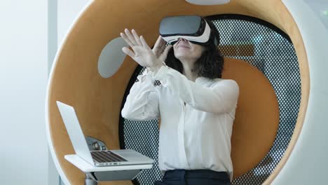 Woman-with-laptop-using-vr-headset